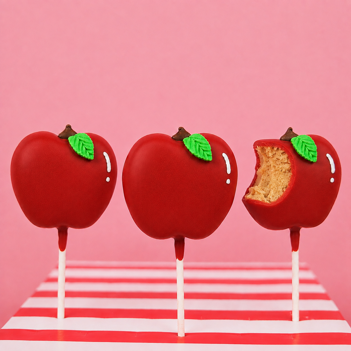 Cross-section of an apple shaped peanut butter creme pop revealing rich creamy center beneath red chocolate coating, handcrafted teacher gift by Nibbles and Bits Scranton PA.