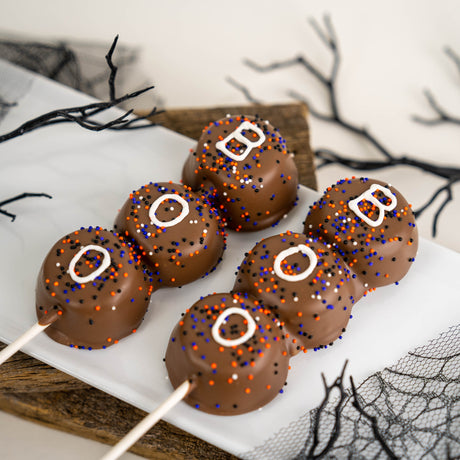 Three handmade marshmallows double dipped in creamy milk chocolate with hand-drawn BOO detail – festive Halloween treat from Nibbles & Bits in Scranton, PA.