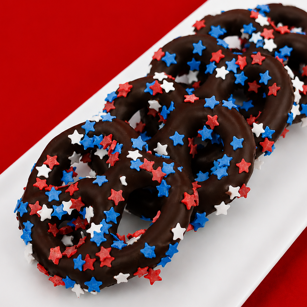 Dark chocolate covered pretzel blanketed in red, white and blue star shaped sprinkles, bold patriotic snack handmade in Scranton Pennsylvania by Nibbles and Bits.