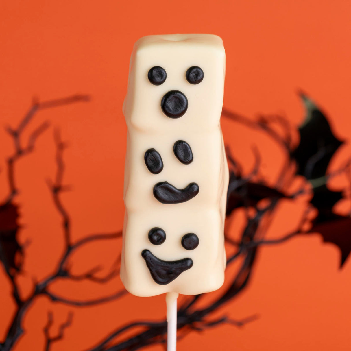 Three handmade marshmallows double dipped in smooth white chocolate with hand-drawn ghost faces – festive Halloween treat from Nibbles & Bits in Scranton, PA.