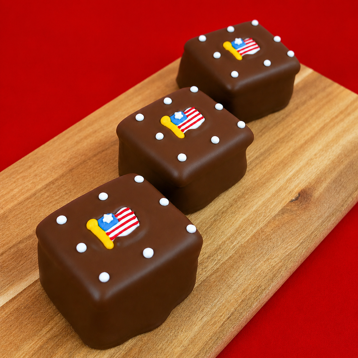 Close-up of patriotic milk chocolate s'more topped with a miniature American flag decal and white dot decorations, festive Fourth of July treat handmade in Scranton Pennsylvania.