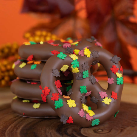 Crunchy Snyder's Olde Tyme pretzels dipped in creamy milk chocolate and decorated with colorful autumn confetti sprinkles – seasonal fall chocolate treat from Nibbles & Bits.