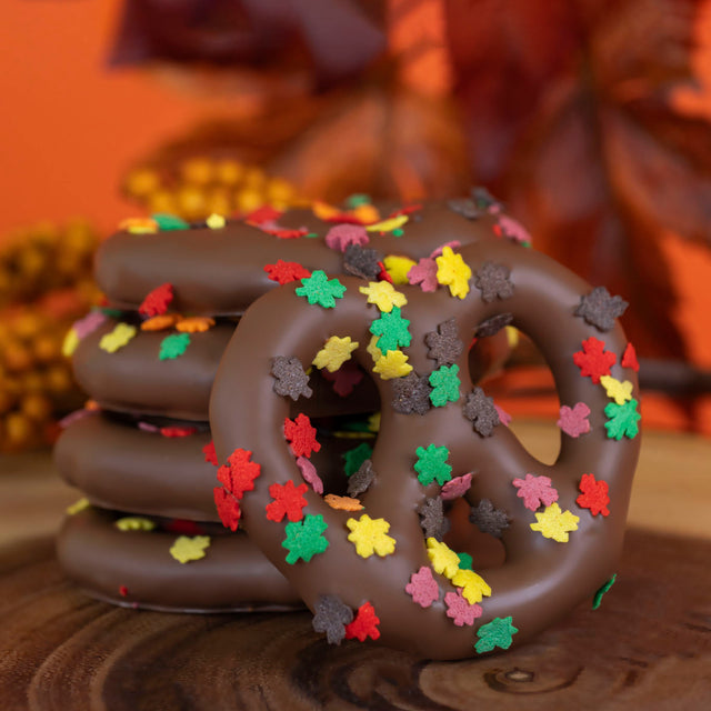 Crunchy Snyder's Olde Tyme pretzels dipped in creamy milk chocolate and decorated with colorful autumn confetti sprinkles – seasonal fall chocolate treat from Nibbles & Bits.