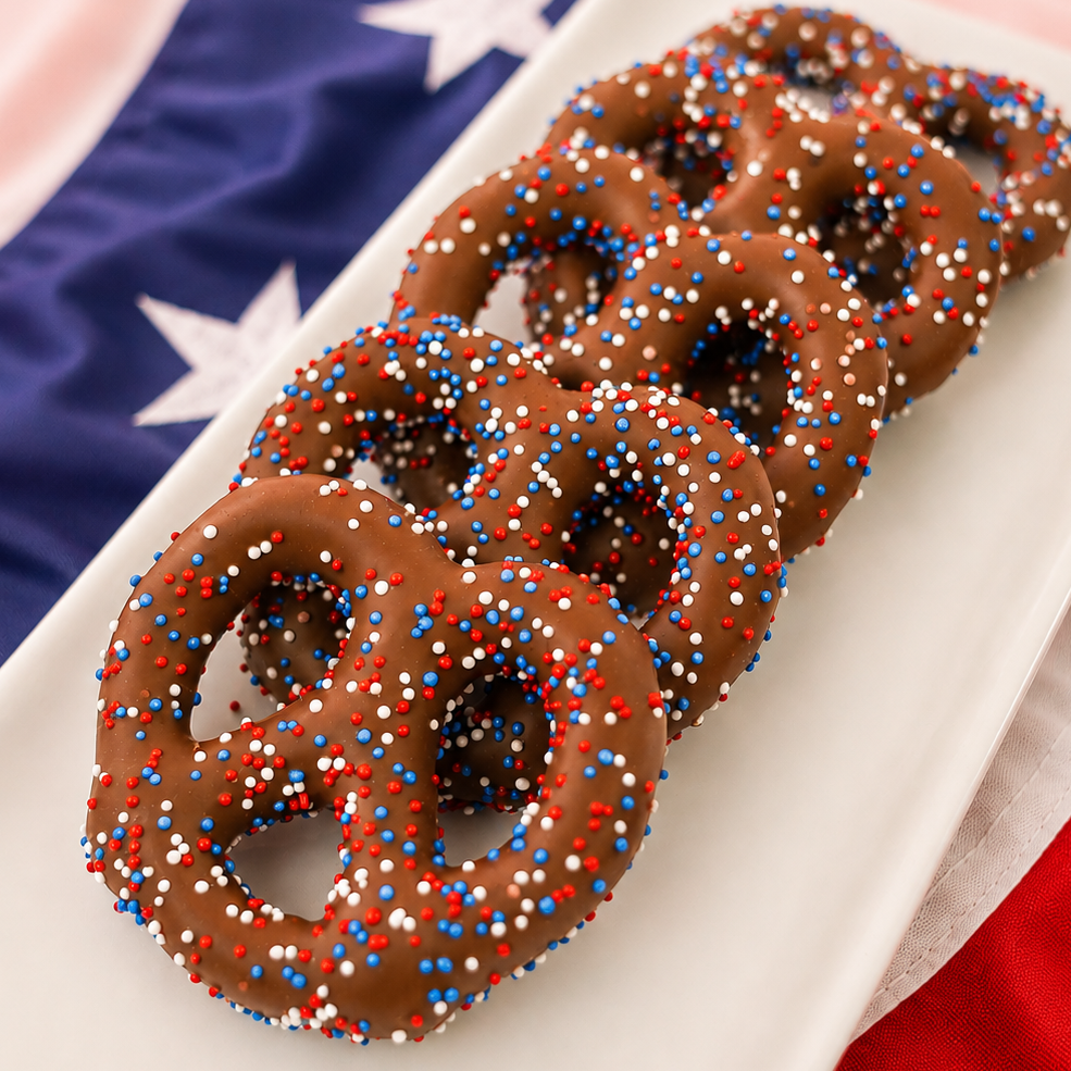 Milk chocolate covered pretzel blanketed in red, white and blue round nonpareil candy beads, classic patriotic snack handmade in Scranton Pennsylvania by Nibbles and Bits.