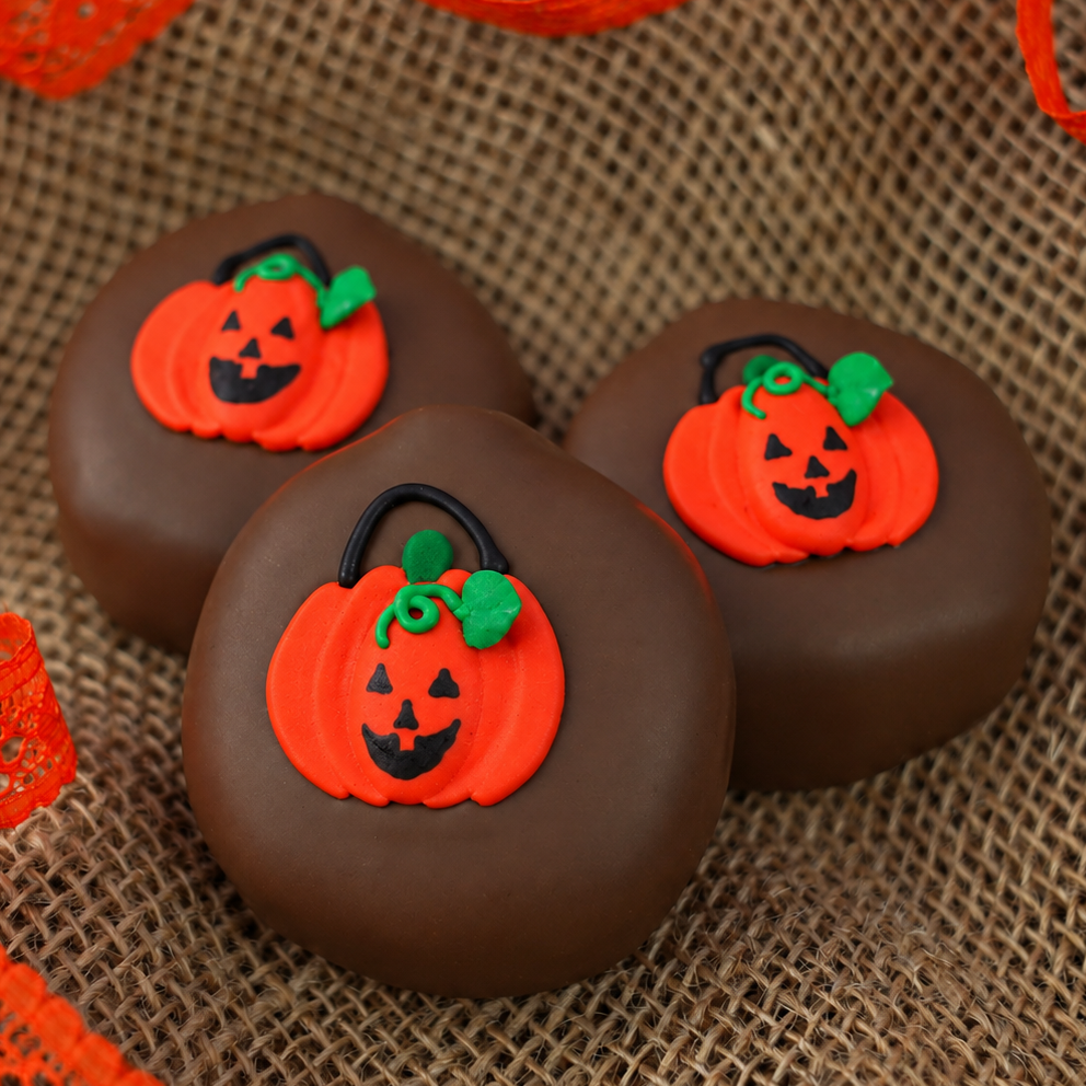 Three Milk Chocolate Peanut Butter Pumpkins on burlap with orange lace ribbon, each topped with a hand-painted trick-or-treat bag decal.