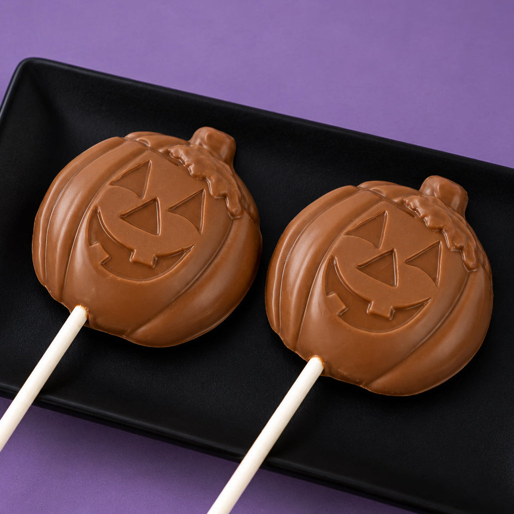 Solid milk chocolate lollipop shaped like a Jack-o-Lantern – handmade Halloween candy from Nibbles & Bits in Scranton, PA.