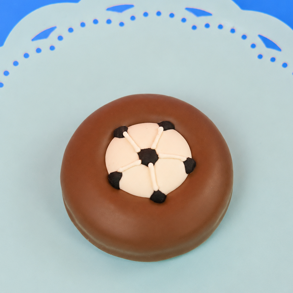Single milk chocolate covered Oreo decorated with a detailed fondant soccer ball featuring black pentagon panels on a mint green decorative plate with blue background, handmade sports gift by Nibbles and Bits Scranton PA.