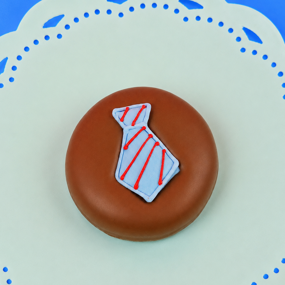 Single milk chocolate covered Oreo decorated with a light blue fondant necktie with hand-piped red diagonal stripes on a mint green decorative plate with blue background, handmade Father's Day gift by Nibbles and Bits Scranton PA.