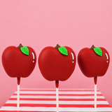 Milk chocolate peanut butter creme pop hand-shaped like a red apple with glossy red chocolate coating green fondant leaf and chocolate kiss stem on a stick, handmade teacher appreciation gift by Nibbles and Bits Scranton PA.