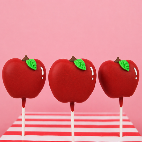 Milk chocolate peanut butter creme pop hand-shaped like a red apple with glossy red chocolate coating green fondant leaf and chocolate kiss stem on a stick, handmade teacher appreciation gift by Nibbles and Bits Scranton PA.