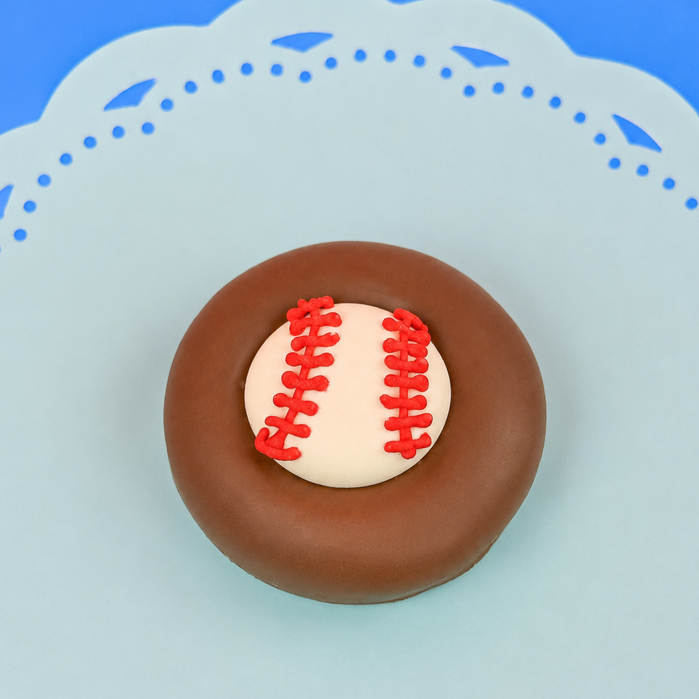 Single milk chocolate covered Oreo decorated with a white fondant baseball and hand-piped red lace stitching on a mint green decorative plate with blue background, handmade sports gift by Nibbles and Bits Scranton PA.
