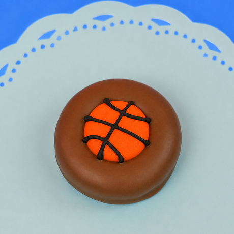 Single milk chocolate covered Oreo decorated with a vibrant orange fondant basketball with dark chocolate seam lines on a mint green decorative plate with blue background, handmade sports gift by Nibbles and Bits Scranton PA.