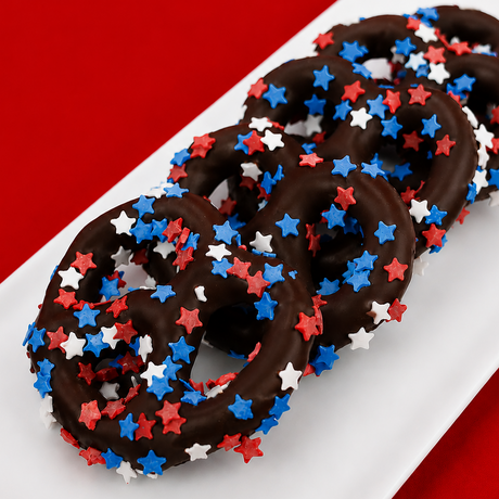 Dark chocolate covered pretzel blanketed in red, white and blue star shaped sprinkles, bold patriotic snack handmade in Scranton Pennsylvania by Nibbles and Bits.