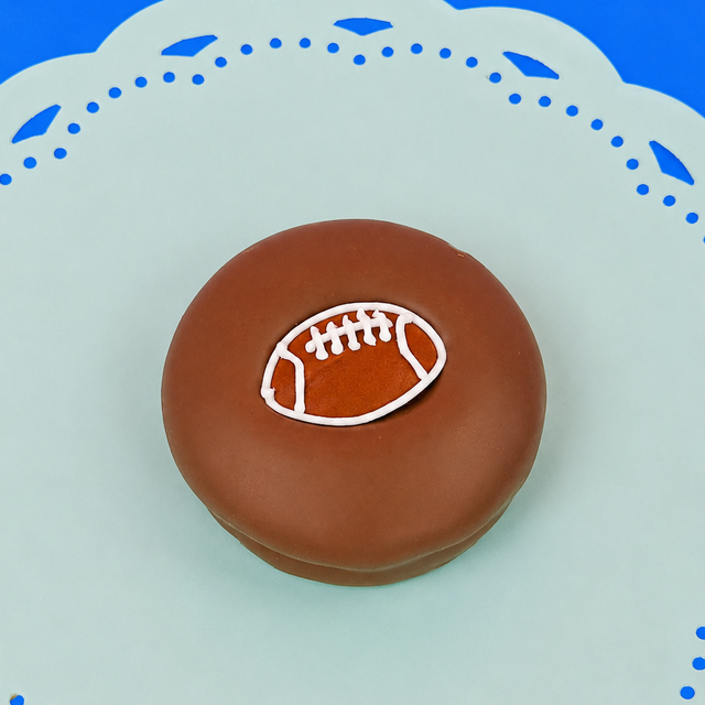 Milk chocolate football Oreo with detailed football decal with white stitching on a mint green plate, handcrafted sports themed chocolate gift by Nibbles and Bits Scranton PA.