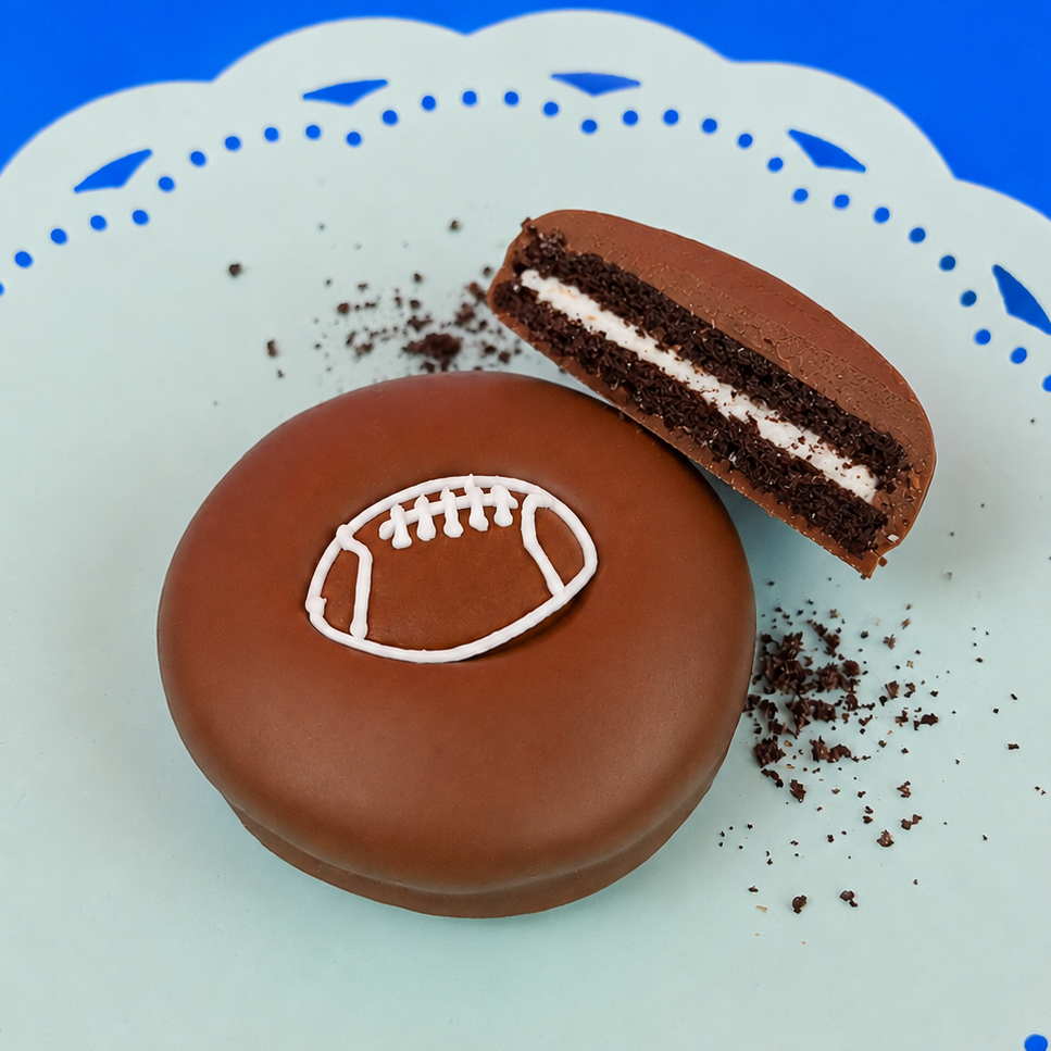 Milk chocolate football Oreo with dark chocolate cookie layers and white cream filling on a mint green plate, handcrafted sports themed chocolate gift by Nibbles and Bits Scranton PA.