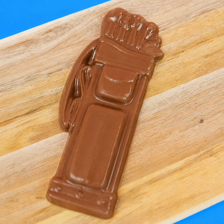 Solid milk chocolate golf bag with detailed molded clubs, pockets and straps displayed on a rustic wood board with blue background, handmade gift for golfers by Nibbles and Bits Scranton PA.
