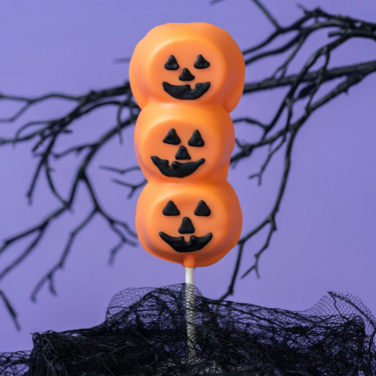 Three handmade marshmallows double dipped in orange white chocolate with hand-drawn Jack-o-Lantern faces – festive Halloween treat from Nibbles & Bits in Scranton, PA.