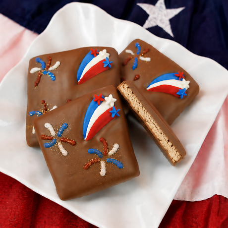 Milk chocolate graham cracker decorated with a red, white and blue fondant shooting star and small patriotic star sprinkles, gourmet Fourth of July dessert handmade in Scranton Pennsylvania. 