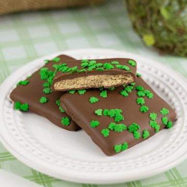 Honey Maid graham crackers double dipped in creamy milk chocolate and topped with green shamrock confetti sprinkles for St. Patrick’s Day.