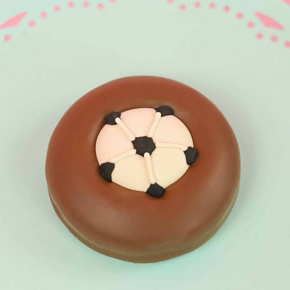 Single milk chocolate covered Oreo decorated with a detailed fondant soccer ball featuring black pentagon panels on a mint green decorative plate with pink background, handmade sports gift by Nibbles and Bits Scranton PA.