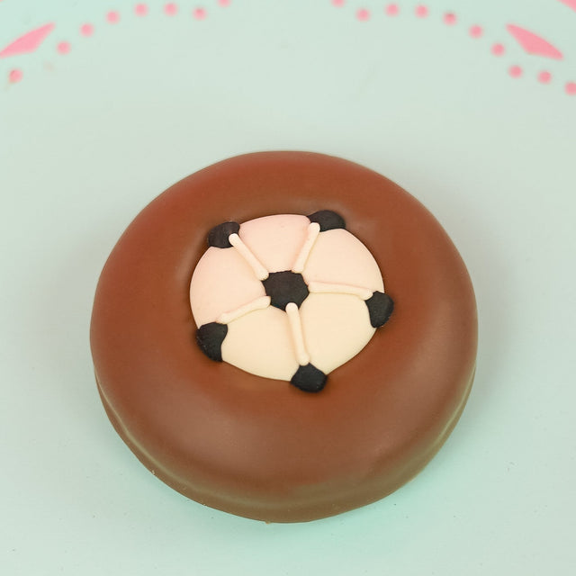 Single milk chocolate covered Oreo decorated with a detailed fondant soccer ball featuring black pentagon panels on a mint green decorative plate with pink background, handmade sports gift by Nibbles and Bits Scranton PA.