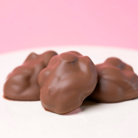 Handmade milk chocolate almond clusters with roasted almonds and creamy chocolate. Perfect for gifts, snacking, and gourmet baskets.