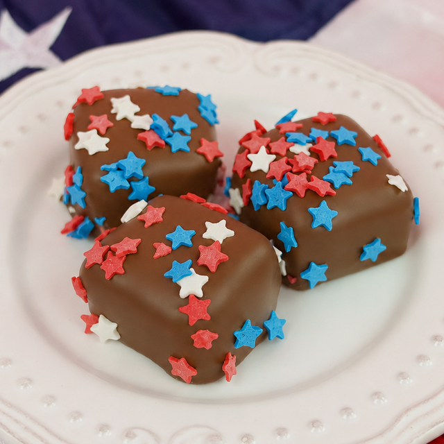 Patriotic milk chocolate marshmallow revealing a thick fluffy white homemade vanilla marshmallow center encased in a smooth milk chocolate shell with star confetti, handcrafted summer treat by Nibbles and Bits Scranton PA.