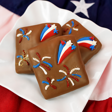 Milk chocolate graham cracker decorated with a red, white and blue fondant shooting star and small patriotic star sprinkles, gourmet Fourth of July dessert handmade in Scranton Pennsylvania. 
