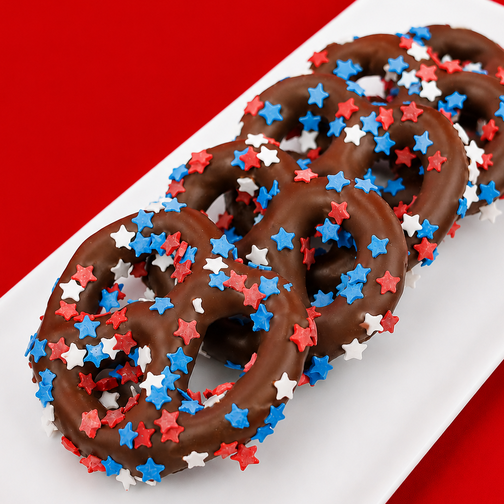 Milk chocolate covered pretzel blanketed in red, white and blue star shaped sprinkles, festive patriotic snack handmade in Scranton Pennsylvania by Nibbles and Bits.