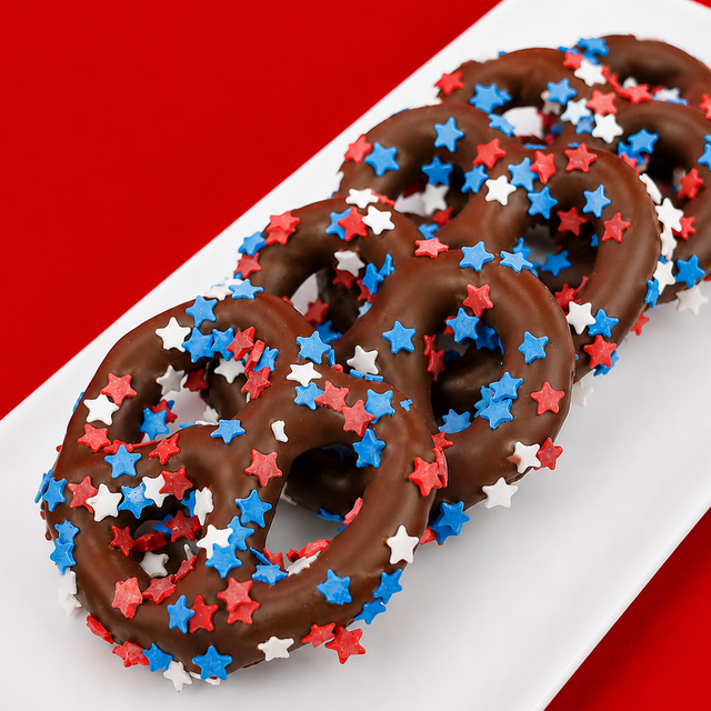 Milk chocolate covered pretzel blanketed in red, white and blue star shaped sprinkles, festive patriotic snack handmade in Scranton Pennsylvania by Nibbles and Bits.