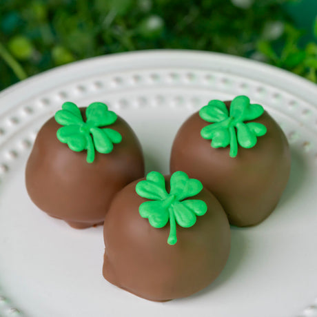 Box of six milk chocolate ganache truffles dipped in smooth milk chocolate and decorated with edible shamrocks, gift boxed and tied with a bow for St. Patrick’s Day.