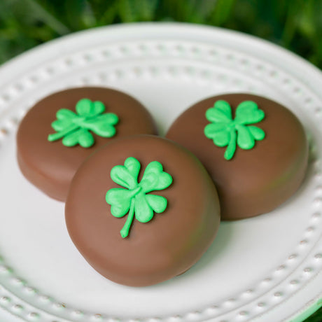 Milk chocolate covered Nabisco Oreo cookie decorated with a hand-drawn shamrock design for St. Patrick’s Day.