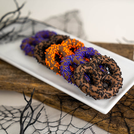 Stack of seven milk chocolate covered pretzels decorated with festive Halloween sprinkles – handmade Halloween treat from Nibbles & Bits in Scranton, PA.