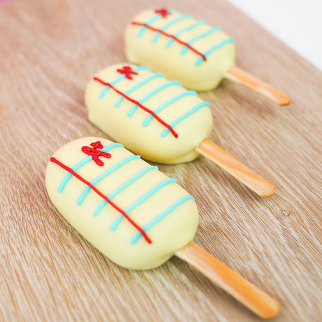 Peanut butter crème pop dipped in white chocolate and hand-detailed to look like notebook paper with blue lines red margin lines and A plus, handmade back to school gift by Nibbles and Bits Scranton PA.