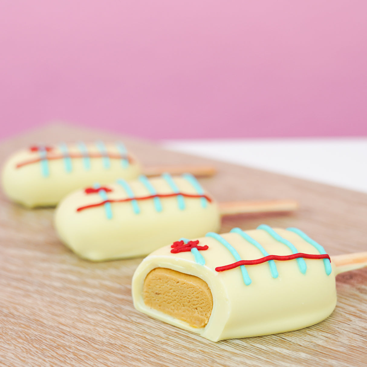 Cross-section of a notebook peanut butter pop revealing rich homemade peanut butter crème center beneath white chocolate notebook paper shell, handcrafted back to school treat by Nibbles and Bits Scranton PA.