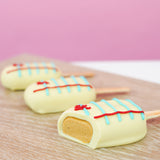 Cross-section of a notebook peanut butter pop revealing rich homemade peanut butter crème center beneath white chocolate notebook paper shell, handcrafted back to school treat by Nibbles and Bits Scranton PA.