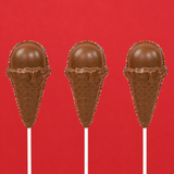 Three solid milk chocolate ice cream cone pops showing detailed molded waffle cone and rounded scoop with patriotic nonpareil border on white sticks against a red background, handmade summer treat by Nibbles and Bits Scranton PA.
