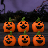 Six Jack O'Lantern Ganache Truffles arranged in two rows, each hand-decorated with a triangle-eyed pumpkin face and green stem.