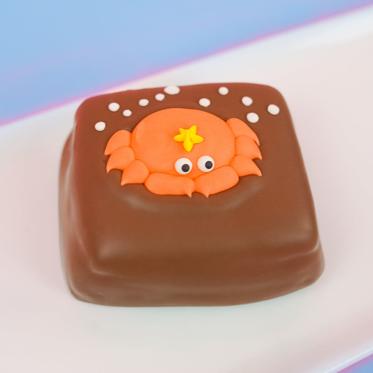 Milk chocolate s'more topped with a cheerful orange fondant crab with googly eyes and yellow starfish detail surrounded by white bubble dots, handmade ocean party favor by Nibbles and Bits Scranton PA.