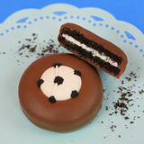 Milk chocolate soccer ball Oreo showing dark chocolate cookie layers and white cream filling on a mint green plate with blue background, handcrafted sports themed chocolate gift by Nibbles and Bits Scranton PA.