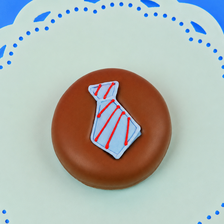 Single milk chocolate covered Oreo decorated with a light blue fondant necktie with hand-piped red diagonal stripes on a mint green decorative plate with blue background, handmade Father's Day gift by Nibbles and Bits Scranton PA.
