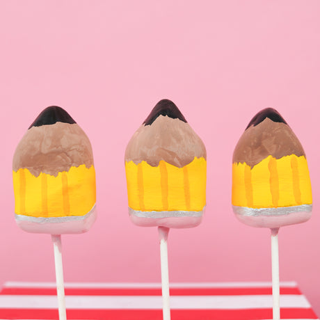Milk chocolate ganache truffle pop hand-shaped and painted as a pencil with yellow barrel silver ferrule pink eraser and graphite tip on a stick, handmade teacher appreciation gift by Nibbles and Bits Scranton PA.