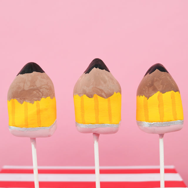 Milk chocolate ganache truffle pop hand-shaped and painted as a pencil with yellow barrel silver ferrule pink eraser and graphite tip on a stick, handmade teacher appreciation gift by Nibbles and Bits Scranton PA.